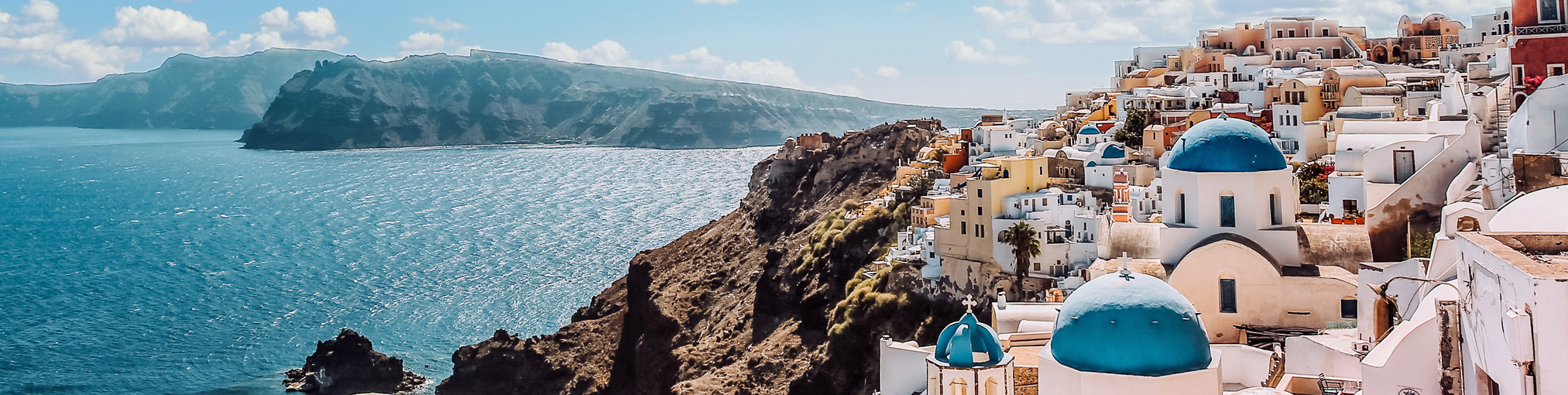 Görög utazás, tengerparti kisváros látképe, kék háztetők, tenger, sziget