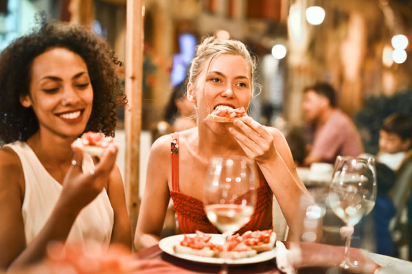 Két nő vidáman, élvezettel vacsorázik egy horvát étteremben