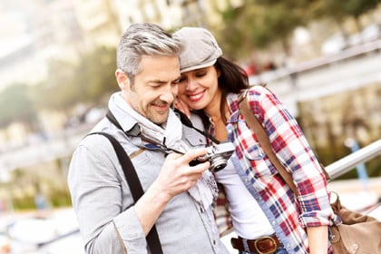 Pár a pálmafás medencénél, utasbiztosítás külföldi utazáshoz