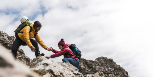 Fiatal túrázók hegyet másznak biztonságban az éves utasbiztosítással