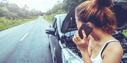 Ázsiai hölgy telefonál nyaralás alatt, mert az autója lerobbant út közben, de szerencsére rendelkezik Mondial utasbiztosítással, így nem kell aggódnia.
