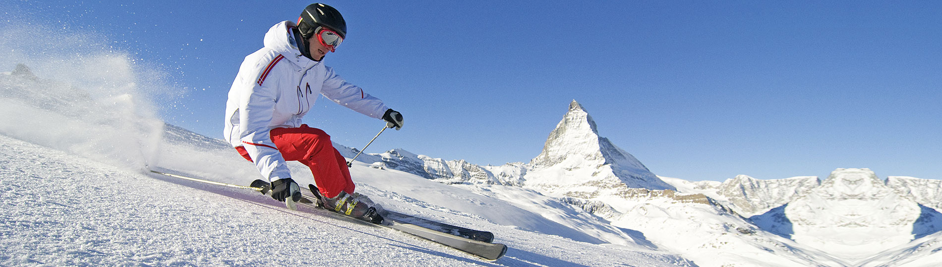 Technikás síelő siklik le a hegyen - Utasbiztosítás téli sportokhoz