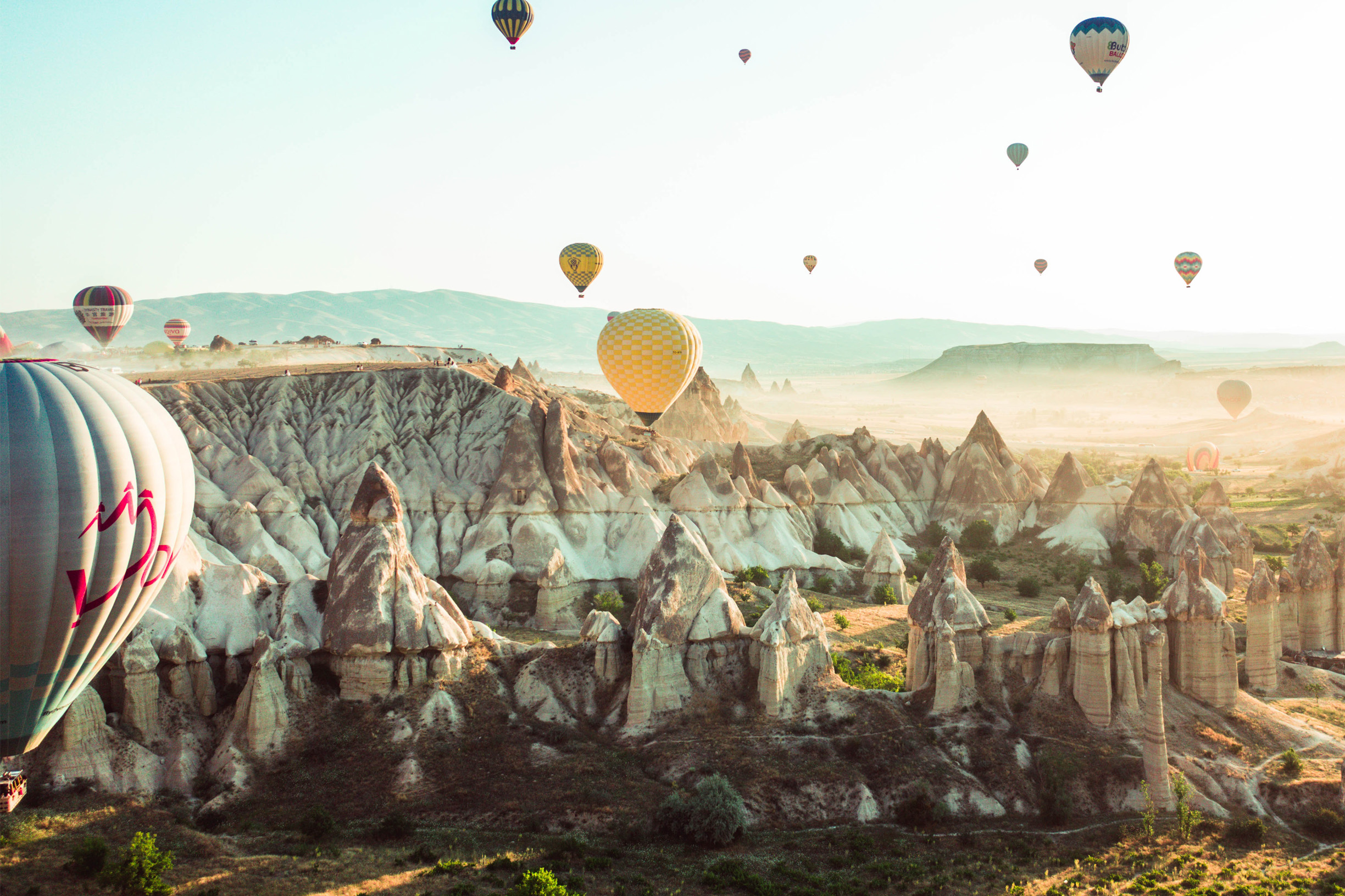 Török táj egzotikus hegyekkel és sok hőlégballonnal, Kappadókiában Törökország középső részén