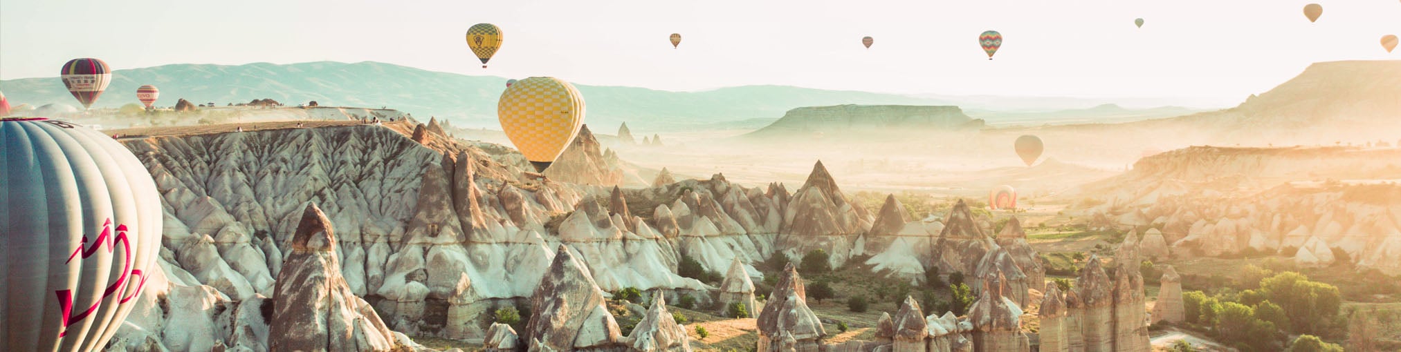 Török táj egzotikus hegyekkel és sok hőlégballonnal, Kappadókiában Törökország