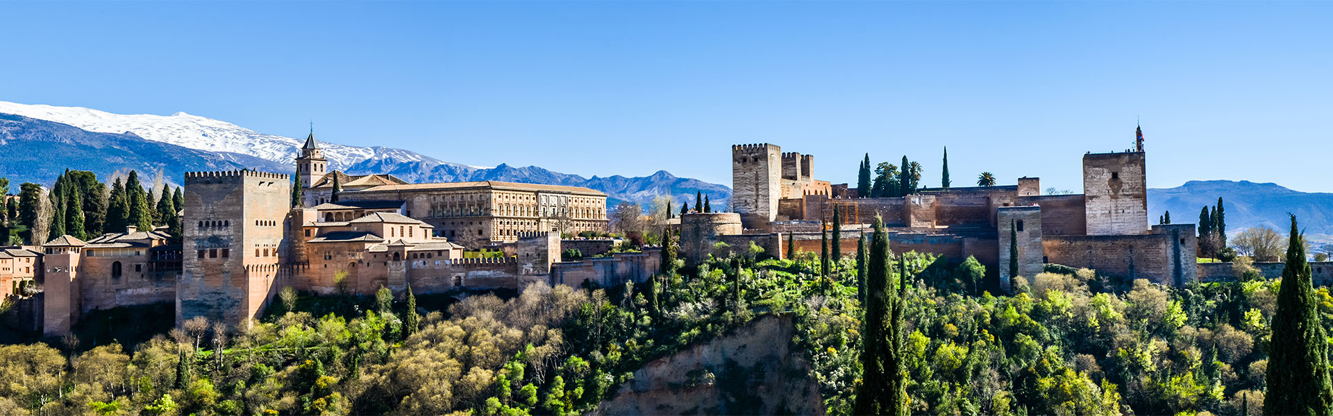 Utasbiztosítás buszos és vonattal történő utazásokhoz, az alhambrai kastély látképe, a spanyolországi Granadában
